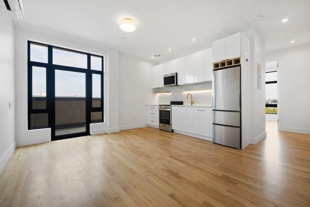 a kitchen with white cabinets and a stainless steel refrigerator